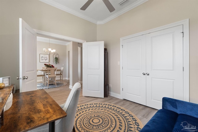 office with light hardwood / wood-style floors, ceiling fan with notable chandelier, and ornamental molding