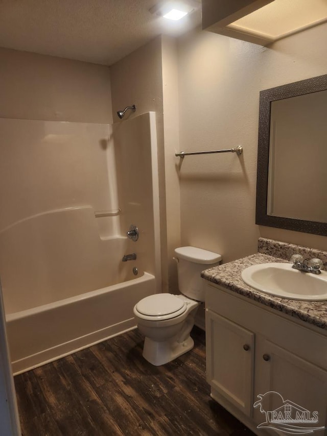 full bathroom featuring toilet, a textured ceiling, vanity, hardwood / wood-style flooring, and shower / bath combination