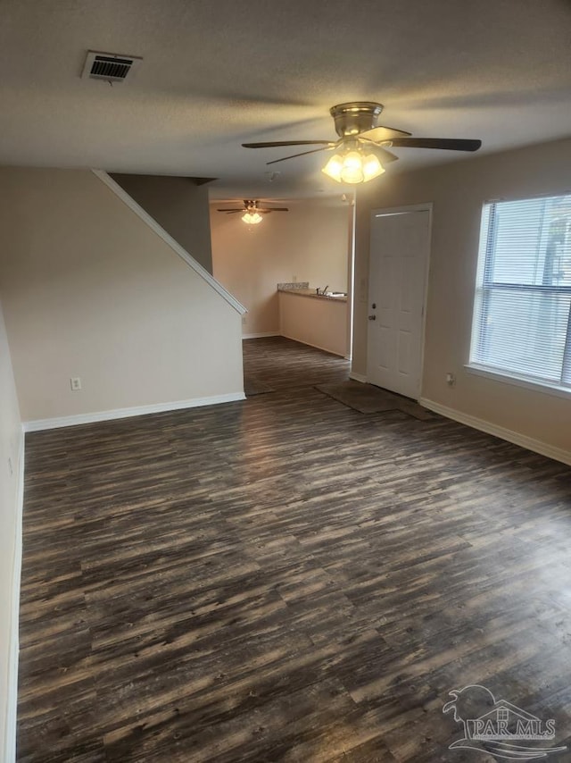 unfurnished room with dark wood-type flooring and a textured ceiling