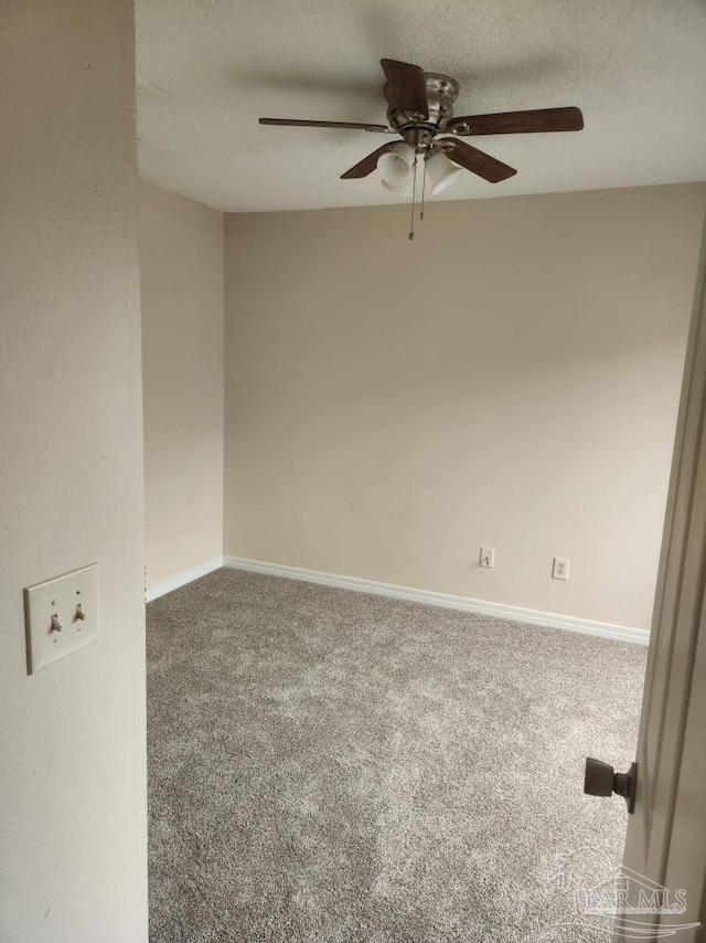 carpeted empty room with ceiling fan and a textured ceiling