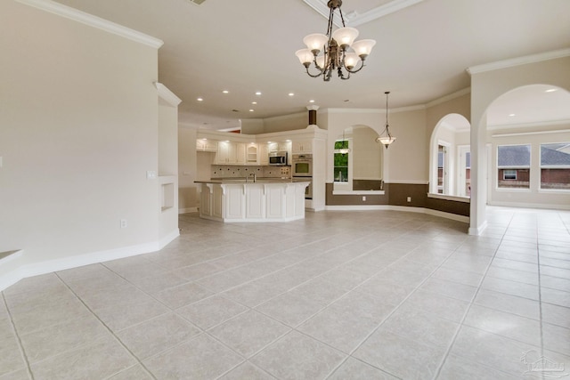 unfurnished living room featuring crown molding, light tile patterned floors, a notable chandelier, and plenty of natural light