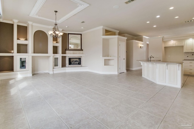 unfurnished living room with sink, ornamental molding, built in features, and light tile patterned flooring