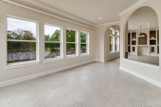 spare room with light tile patterned floors, a notable chandelier, ornamental molding, and built in shelves