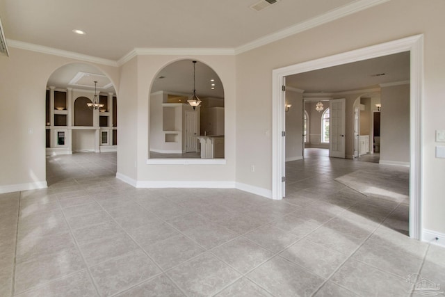 empty room with light tile patterned floors, crown molding, a chandelier, and built in shelves