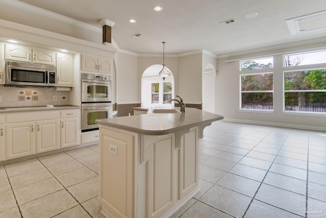 kitchen with pendant lighting, sink, ornamental molding, light tile patterned floors, and stainless steel appliances