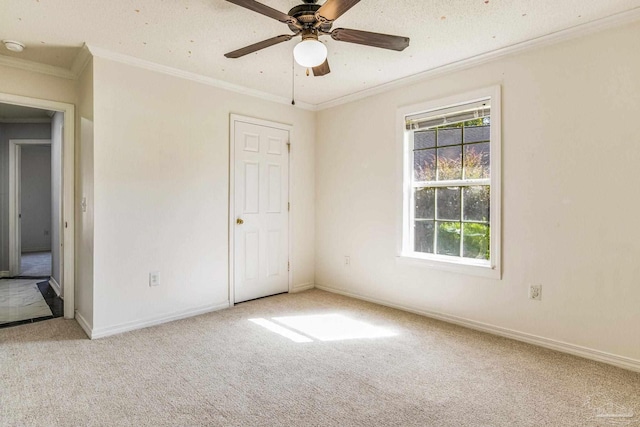 unfurnished bedroom featuring ceiling fan, crown molding, light colored carpet, and a textured ceiling