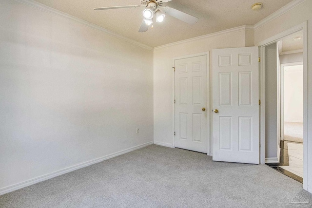 unfurnished bedroom featuring ceiling fan, ornamental molding, a textured ceiling, light colored carpet, and a closet