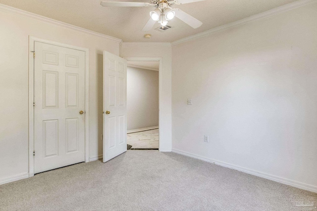 unfurnished bedroom featuring a textured ceiling, ceiling fan, ornamental molding, and light carpet