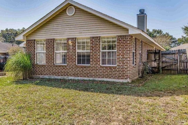 view of side of home with a yard