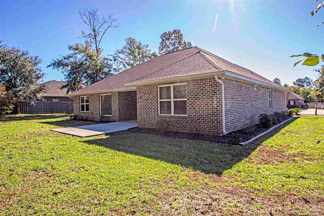 rear view of property featuring a lawn and a patio area