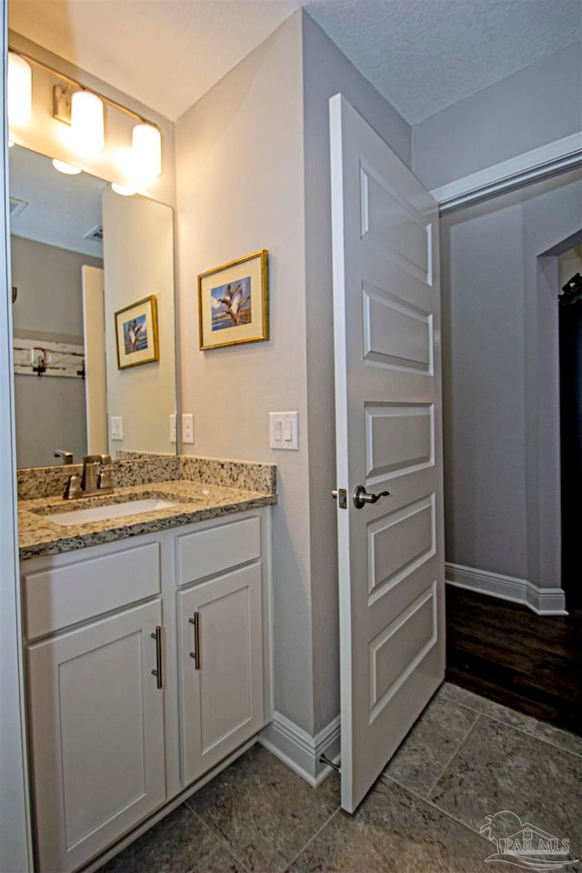 bathroom featuring tile patterned flooring, a textured ceiling, and vanity