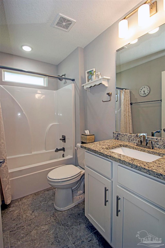 full bathroom with vanity, a textured ceiling, shower / tub combo with curtain, and toilet