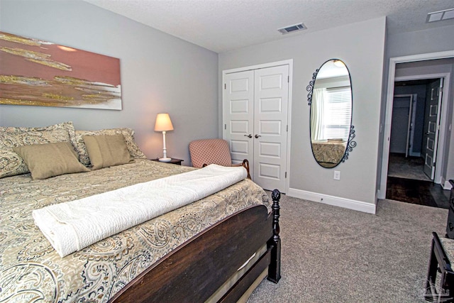 carpeted bedroom featuring a textured ceiling and a closet