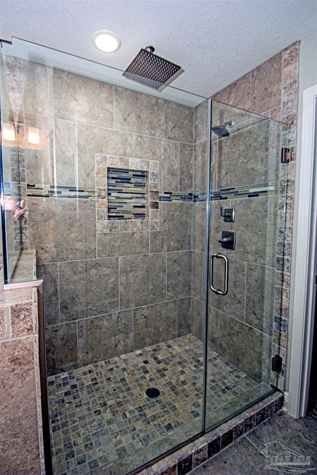 bathroom featuring a textured ceiling and an enclosed shower