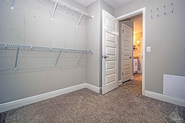 spacious closet with dark carpet