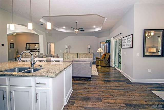 kitchen featuring dark hardwood / wood-style floors, white cabinetry, sink, and decorative light fixtures