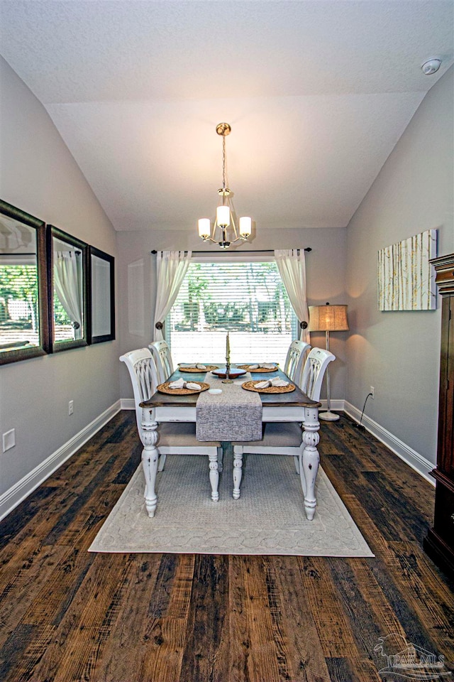 dining area featuring a notable chandelier, lofted ceiling, and dark wood-type flooring