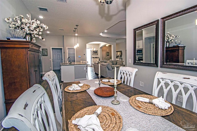 dining area featuring hardwood / wood-style floors, a textured ceiling, and sink