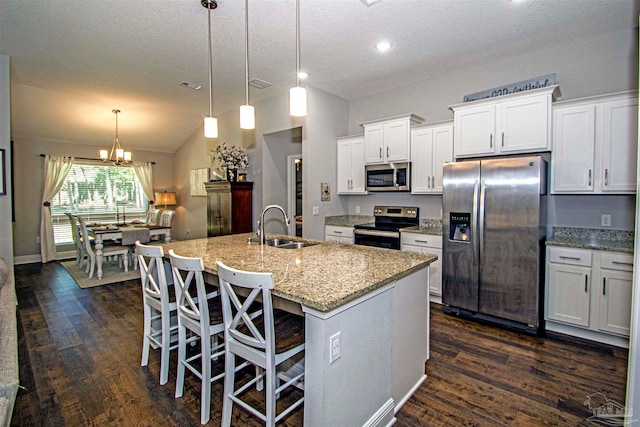 kitchen featuring stainless steel appliances, white cabinetry, a center island with sink, and sink