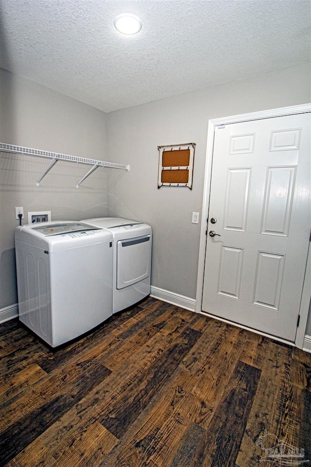 laundry room with washing machine and dryer, dark hardwood / wood-style flooring, and a textured ceiling