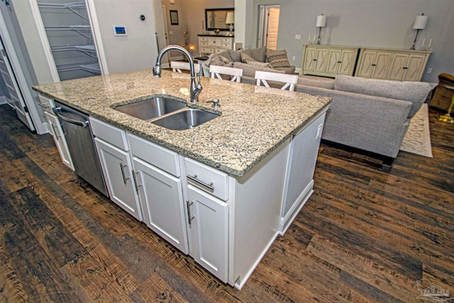 kitchen with sink, light stone counters, dark hardwood / wood-style floors, a kitchen island with sink, and white cabinets