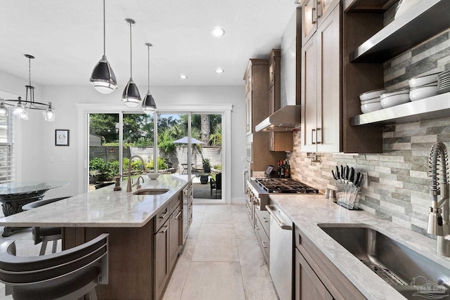 kitchen featuring pendant lighting, dishwasher, light stone counters, tasteful backsplash, and sink