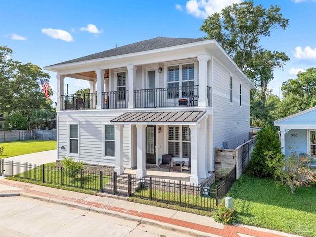 view of front of home featuring a balcony and a front lawn