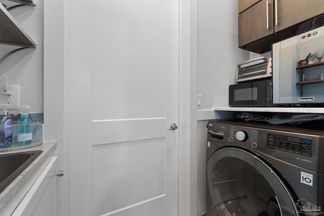 laundry area with cabinets and washer / dryer