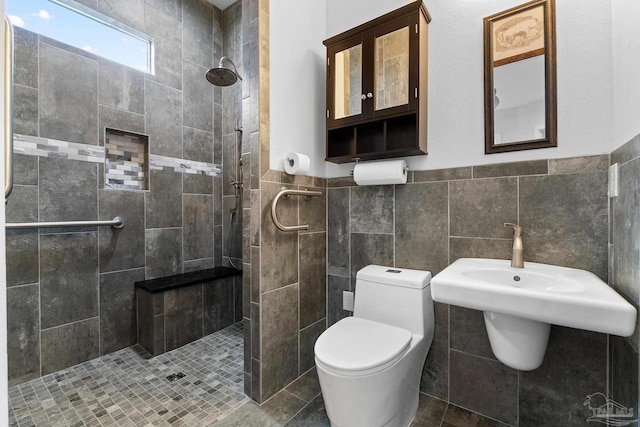 bathroom featuring tile walls, toilet, and tiled shower