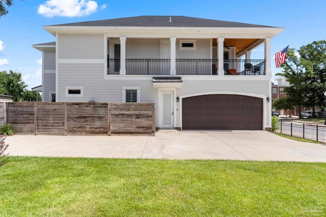 view of front of home featuring a balcony, a garage, and a front lawn