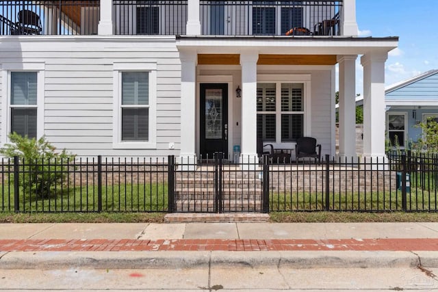 entrance to property featuring a balcony and covered porch