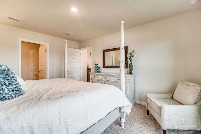 bedroom with light colored carpet and a textured ceiling