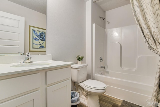 full bathroom with shower / washtub combination, hardwood / wood-style floors, vanity, toilet, and a textured ceiling