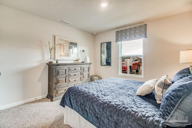 bedroom featuring carpet and a textured ceiling