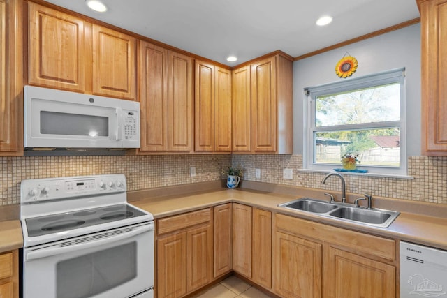 kitchen featuring light tile patterned floors, tasteful backsplash, light countertops, a sink, and white appliances