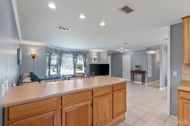 kitchen with light countertops, light tile patterned flooring, visible vents, and crown molding