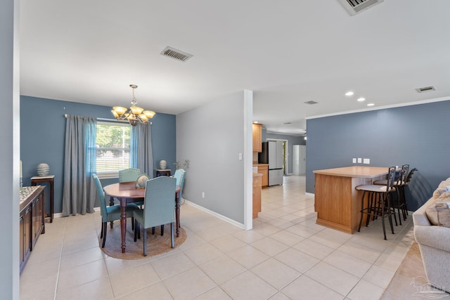 dining room with an inviting chandelier, light tile patterned floors, and visible vents