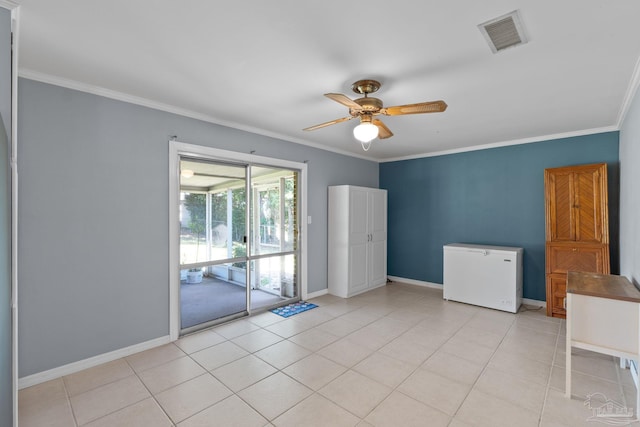 empty room with light tile patterned flooring, visible vents, and ornamental molding