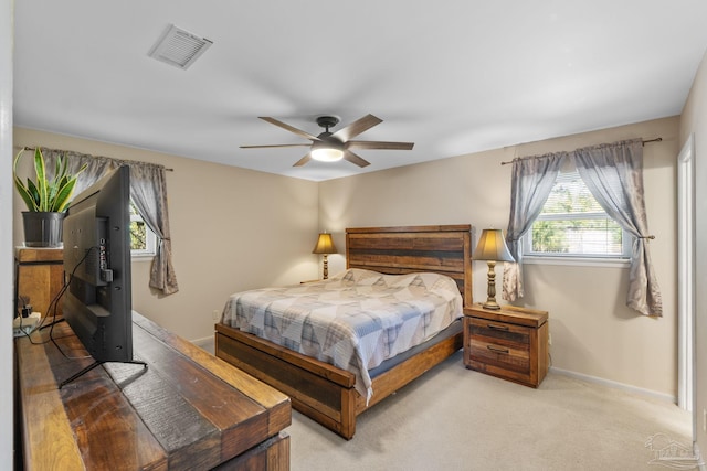 bedroom featuring light carpet, a ceiling fan, visible vents, and baseboards