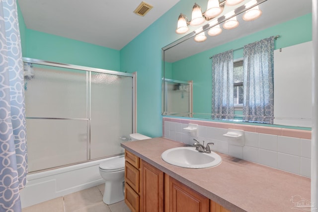 bathroom with tile patterned flooring, toilet, shower / bath combination with glass door, vanity, and visible vents