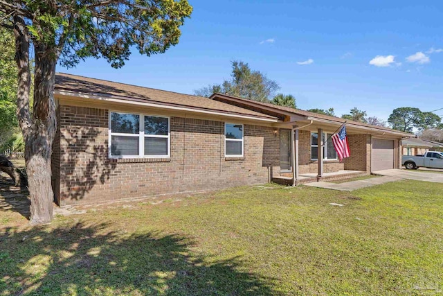 single story home featuring driveway, brick siding, an attached garage, and a front yard