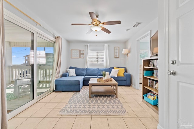 tiled living room with ceiling fan and a wealth of natural light