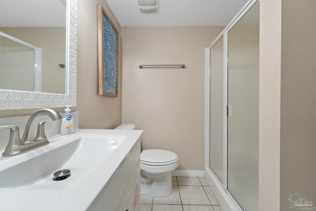 bathroom featuring tile patterned flooring, a shower with door, vanity, and toilet