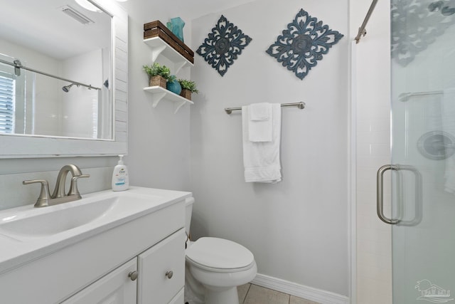 bathroom featuring tile patterned flooring, walk in shower, vanity, and toilet