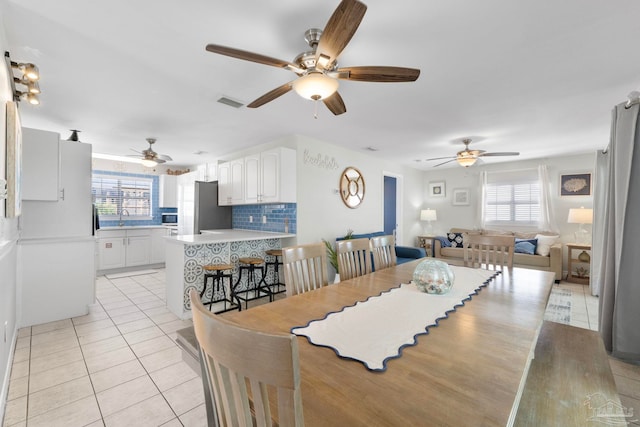 dining area with light tile patterned floors, sink, and ceiling fan