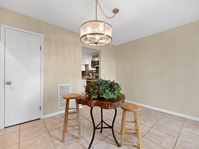 2701 E De Soto St, Pensacola, FL 32503 - dining room with a chandelier, light tile patterned floors, and baseboards