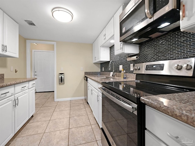 2701 E De Soto St, Pensacola, FL 32503 - kitchen featuring stainless steel appliances, a sink, tasteful backsplash, and white cabinetry