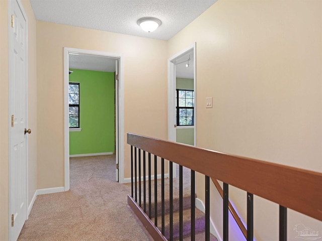 2701 E De Soto St, Pensacola, FL 32503 - hall with carpet, an upstairs landing, baseboards, and a textured ceiling