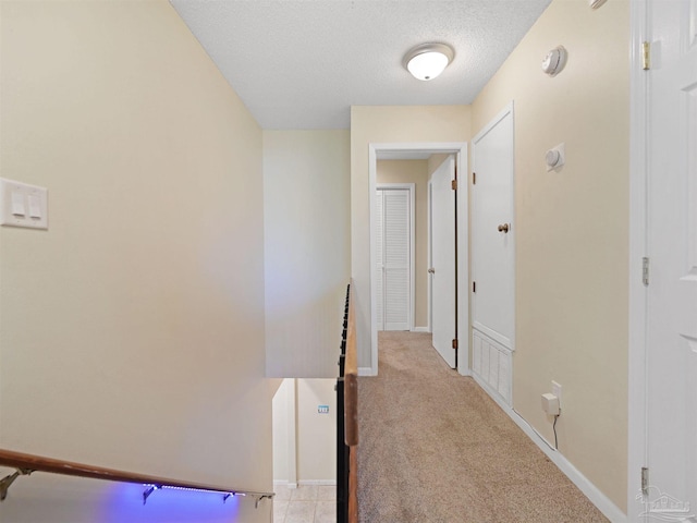 2701 E De Soto St, Pensacola, FL 32503 - hallway featuring a textured ceiling, light carpet, and baseboards