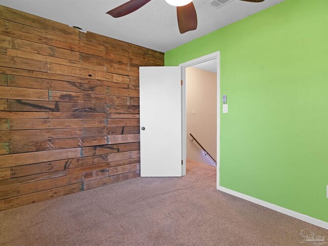 2701 E De Soto St, Pensacola, FL 32503 - carpeted spare room with wooden walls and a ceiling fan